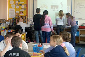 Primary classroom in UK with students using interactive whiteboard
